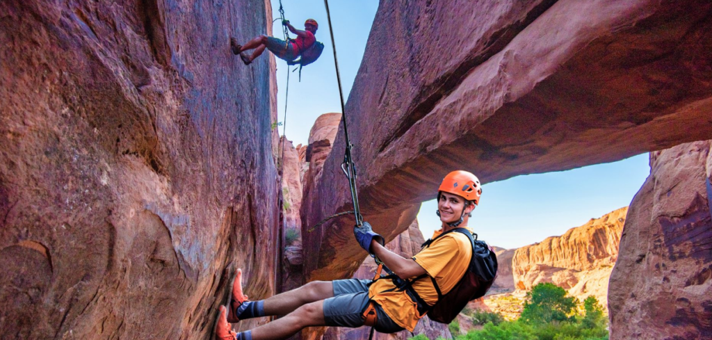Smiling guest rappelling in Grandstaff Canyon near Morning Glory Arch Moab