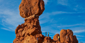 Family exploring Balanced Rock in Arches National Park