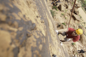 Rock climber with red rock canyon backdrop in Moab Utah