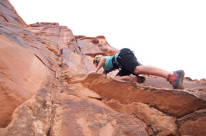 Rock climber silhouetted against sky in Moab Utah