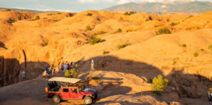 Guests standing at canyon overlook during sunset Hummer tour