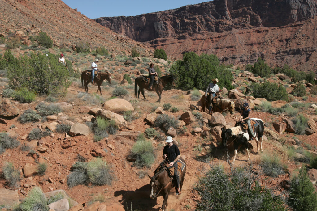 Horseback riders crossing small desert creek on Moab trail ride