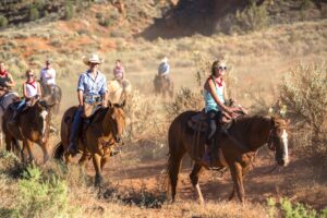 Horseback riders traveling through desert trail with sagebrush near Moab